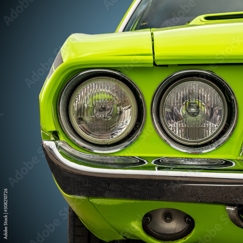 Headlights of a bright green American sports car