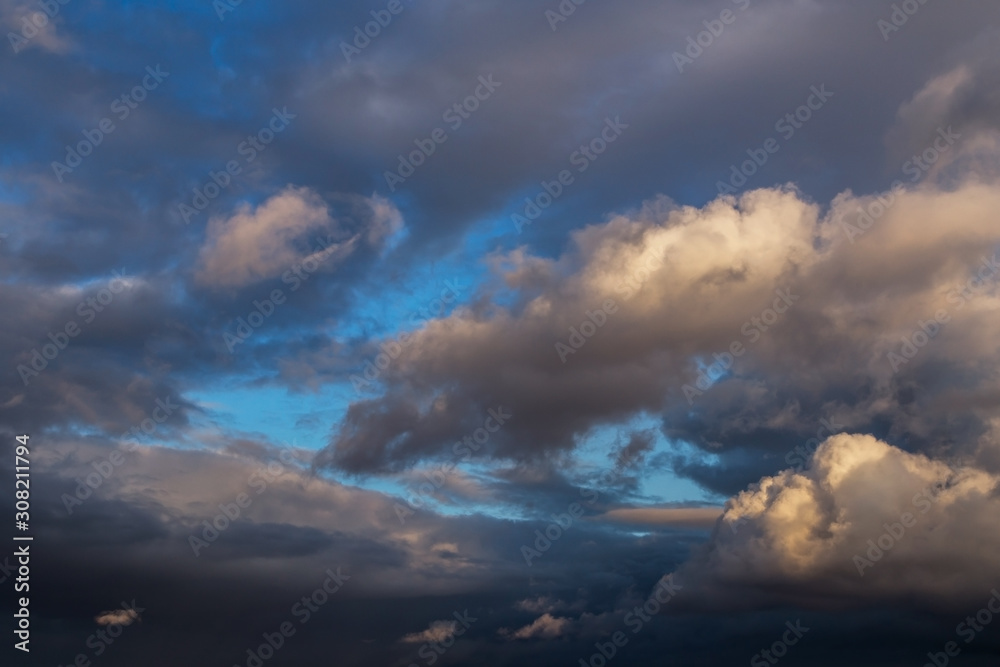 Obraz premium Dramatic epic storm grey cumulus clouds against blue sky background texture 