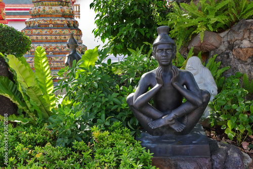 Closeup hermit statue at Wat Pho or ruesi datton showing one position of Thai yoga by lifting and crossing legs   photo