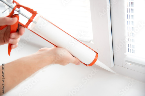 Принти на полотні Construction worker use gun silicone tube for repairing and installing window in