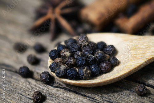 Close-up of black peppercorns on wooden spoon