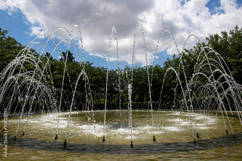 Chorros de una fuente con fondo de nubes 