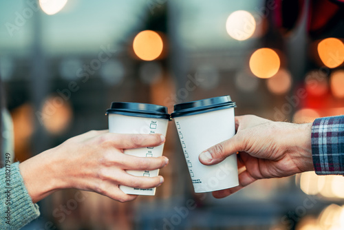 a couple is toasting with paper cup and drink coffee © Sondem