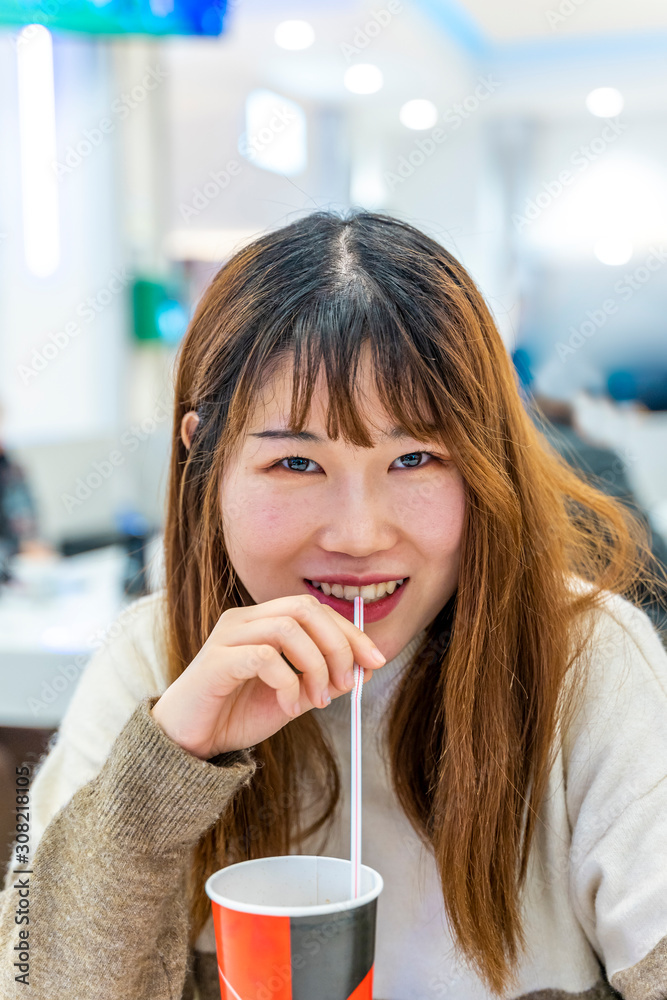 portrait of chinese young adult drinking a soft drink portrait of chinese young adult drinking a soft drink
