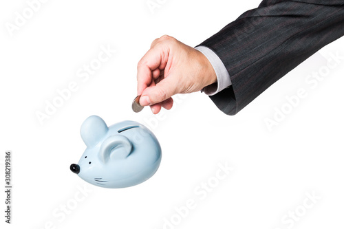 Businessman hand inserting coin into piggy Bank, isolated, concept for business and save money. Detail of a businessman's hand inserting a coin into a moneybox in the form of a mouse