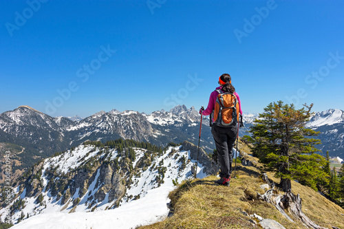 Female hiker walking in alpine landscape in spring. Allgau Alps, Tirol, Austria. Copy space