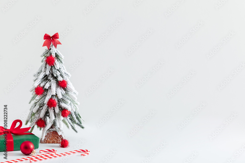 Obraz premium Christmas holiday composition. Xmas tree, decoration and gift on white background. Christmas, New Year, winter concept. Front view, copy space