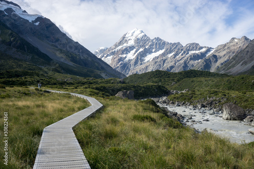 Hiking path along a river towards a mountain