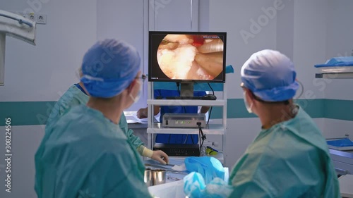 Operating process on the screen of a computer. Surgeons use a tool with camera while performing a surgery on a patient. Medical concept. photo