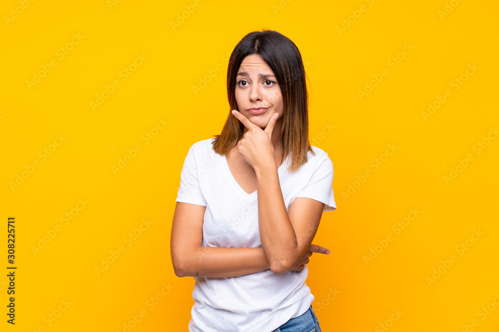 Young woman over isolated yellow background thinking Young woman over isolated yellow background thinking