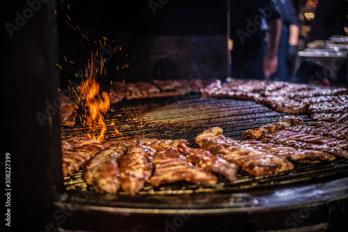 Fried meat  rib meaton a black background of charcoal. Cooked juicy ribs on charcoal. Fried ribs on charcoal.