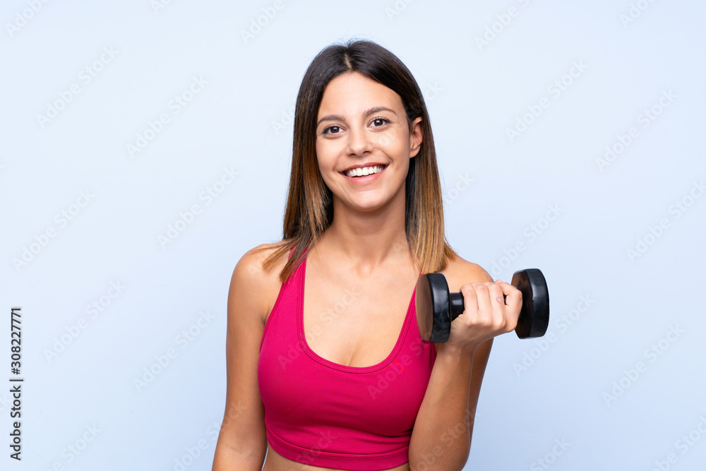 Young sport woman over isolated blue background making weightlifting Young sport woman over isolated blue background making weightlifting