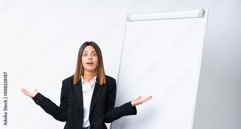 Young woman giving a presentation on white board with shocked facial expression Young woman giving a presentation on white board with shocked facial expression