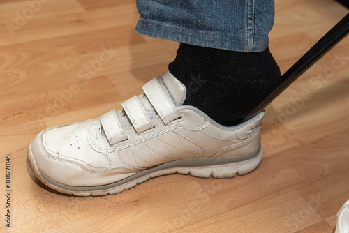 Wallpaper Mural Einstieg in weißen Sportschuh mit Hilfe eines Schuhanziehers Torontodigital.ca