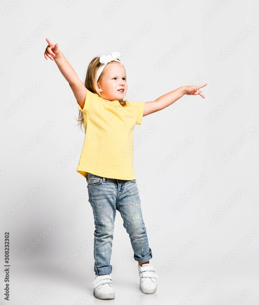 Φωτογραφία Kid baby girl in yellow t-shirt is dancing waltzing, playing princess, having fu