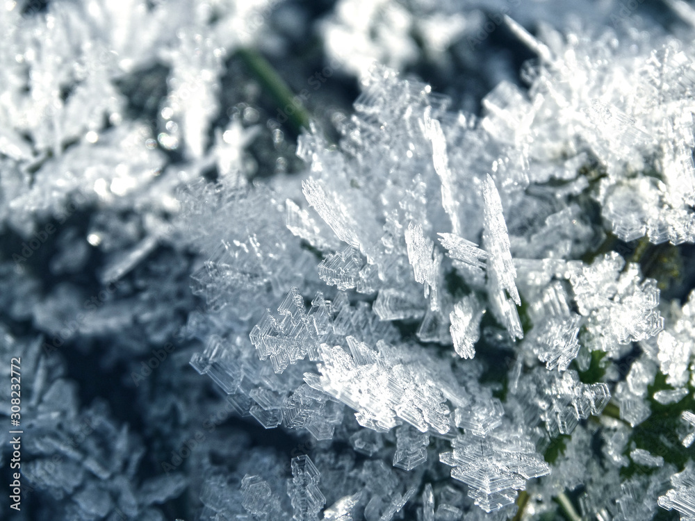 winter background with snowflakes crystals patterns and snow on frozen grass