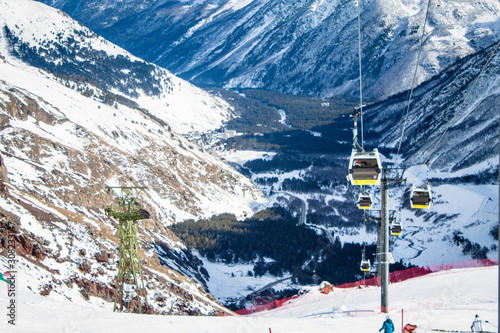 Magnificent view of the snow-white towering mighty mountains Elbrus and the cable ways, ski resort, Kabardinobalkaria, Russia photo