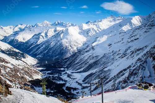 Magnificent view of the snow-white towering mighty mountains Elbrus and the cable ways, ski resort, Kabardinobalkaria, Russia photo