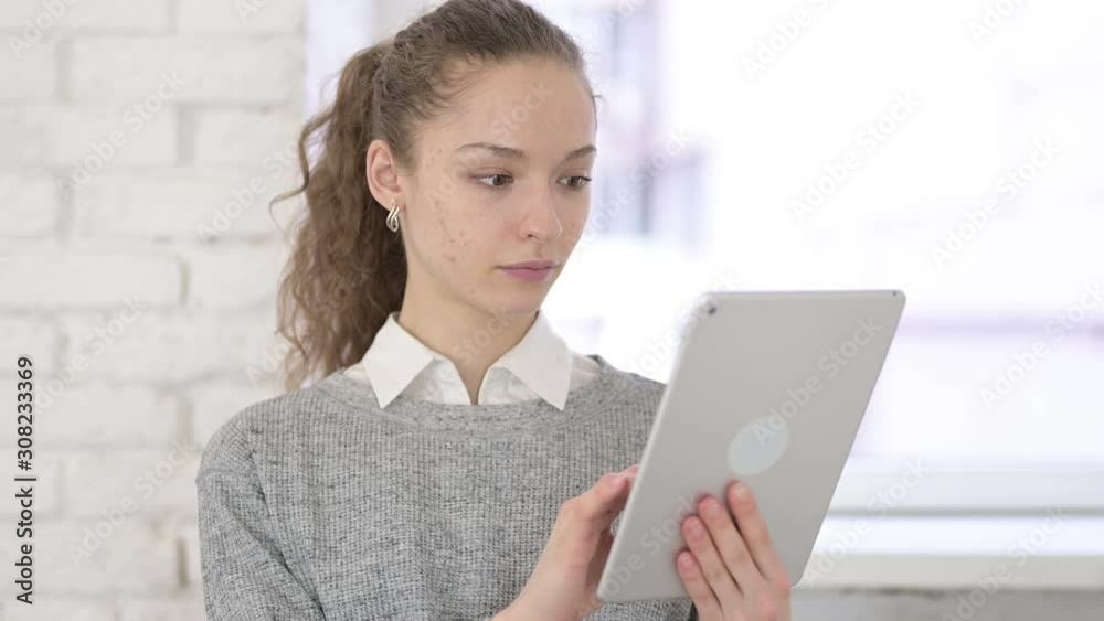Portrait of Serious Young Latin Woman using Tablet