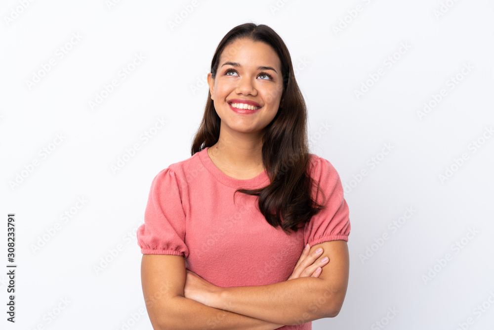 Young Colombian girl over isolated white background looking up while smiling Young Colombian girl over isolated white background looking up while smiling