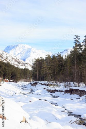 Winter snow forest landscape and river Baksan on mountain Elbrus, ski resort, the Republic of Kabardino-Balkaria, Russia.