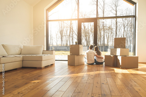 young couple moves to a new home. the family carries boxes of things after buying a home.