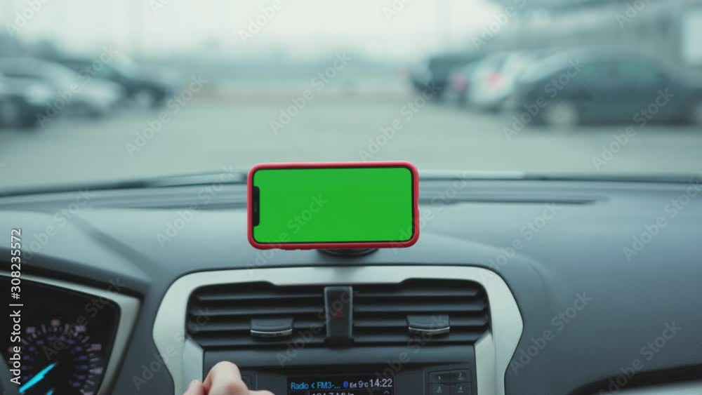 Hands man drive car smartphone with horizontal green screen display on the dashboard application technology transport inside phone business car phone cell device screen digital close up slow motion Hands man drive car smartphone with horizontal green screen display on the dashboard application technology transport inside phone business car phone cell device screen digital close up slow motion