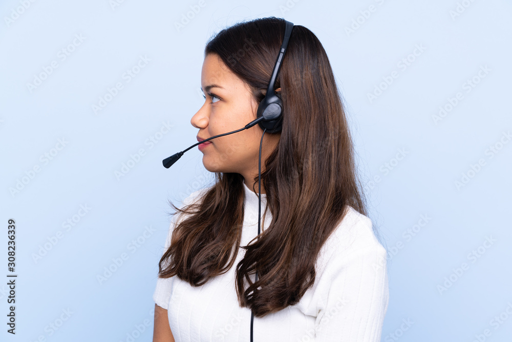 Young telemarketer Colombian woman over isolated blue background looking to the side Young telemarketer Colombian woman over isolated blue background looking to the side