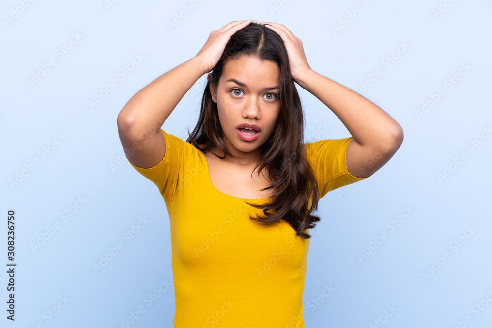 Fototapeta premium Young Colombian girl over isolated blue background with surprise facial expression