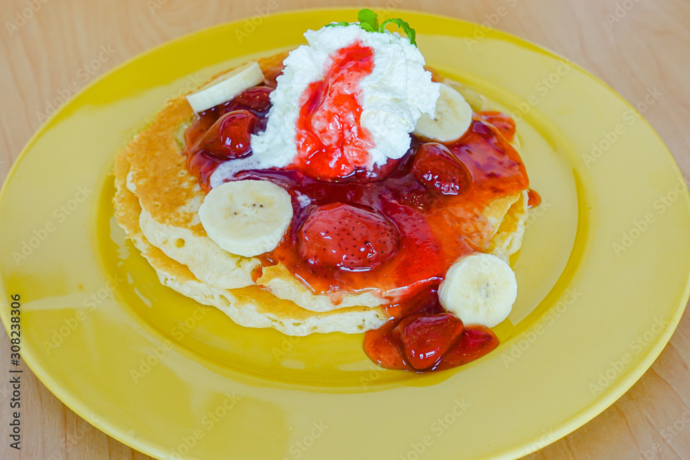 Pancakes served with banana, strawberry, strawberry jam and whipped cream Pancakes served with banana, strawberry, strawberry jam and whipped cream