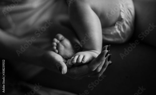 Mom’s hands are holding baby’s legs © Angelina
