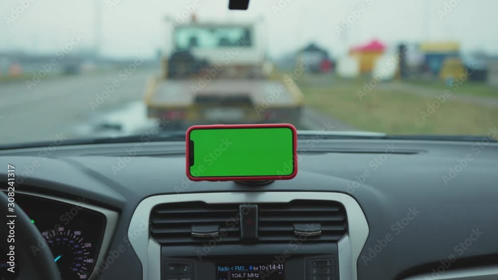 Hands man drive car smartphone with horizontal green screen display on the dashboard application technology transport inside phone business car phone cell device screen digital close up slow motion Hands man drive car smartphone with horizontal green screen display on the dashboard application technology transport inside phone business car phone cell device screen digital close up slow motion