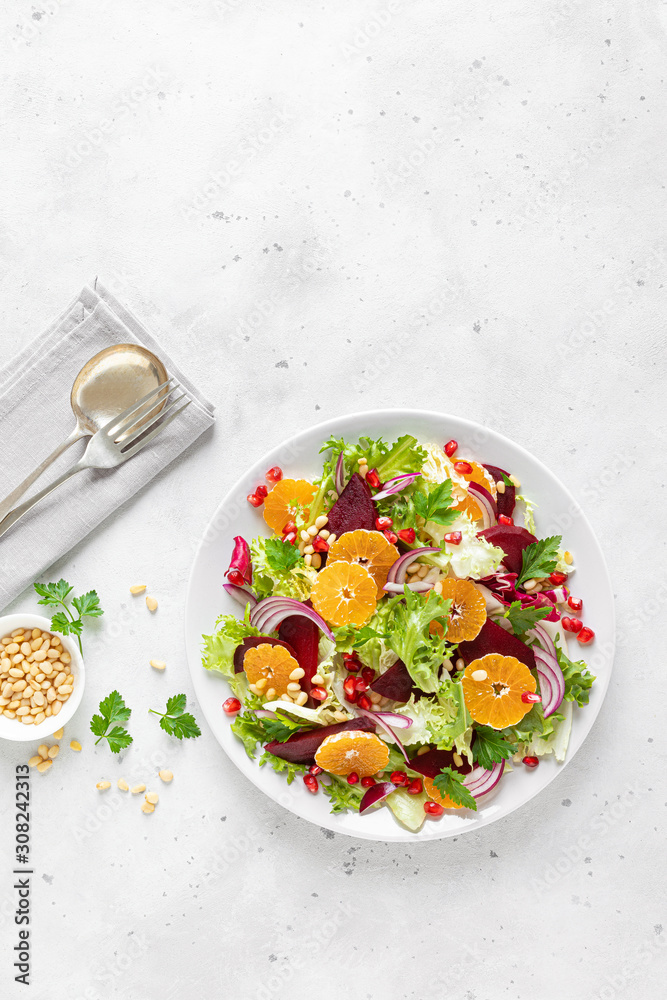 Christmas salad with boiled beet, red onion, tangerines, pomegranate, parsley, pine nuts and lettuce leaves Christmas salad with boiled beet, red onion, tangerines, pomegranate, parsley, pine nuts and lettuce leaves