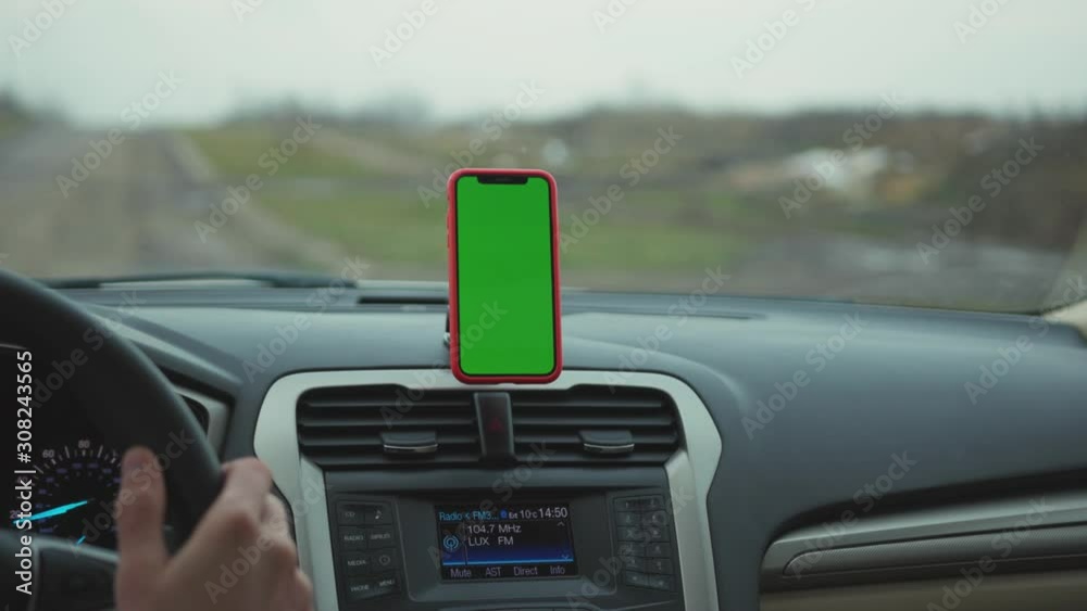 Close up hands man drive car smartphone with green screen display on the dashboard application technology transport inside phone business car phone cell auto device screen digital slow motion Close up hands man drive car smartphone with green screen display on the dashboard application technology transport inside phone business car phone cell auto device screen digital slow motion