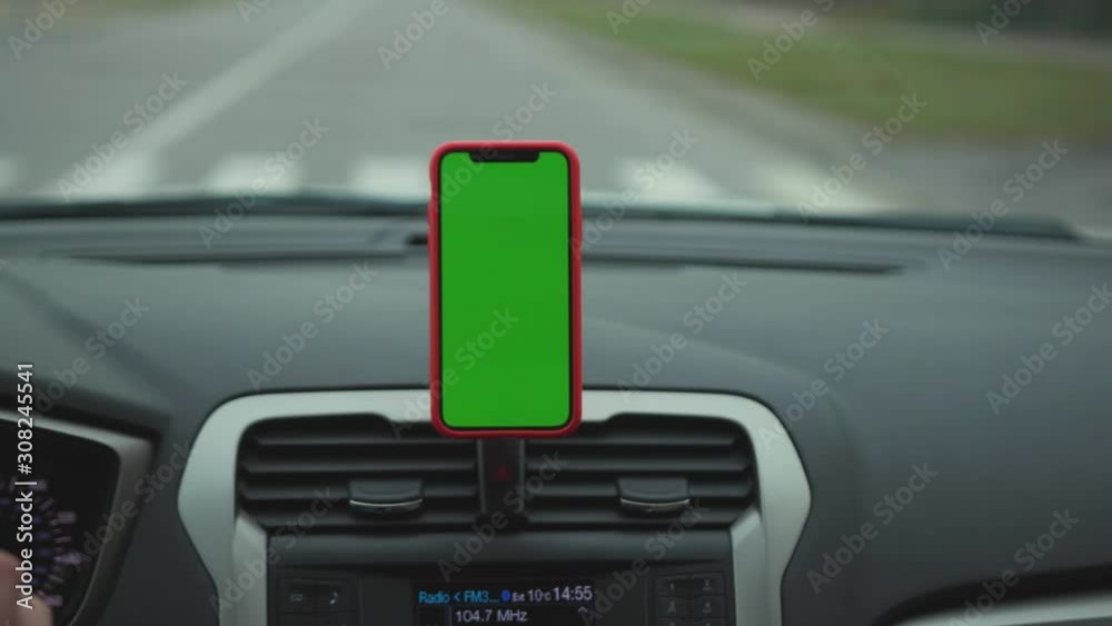 Close up hands man drive car smartphone with green screen display on the dashboard application technology transport inside phone business car phone cell auto device screen digital slow motion Close up hands man drive car smartphone with green screen display on the dashboard application technology transport inside phone business car phone cell auto device screen digital slow motion