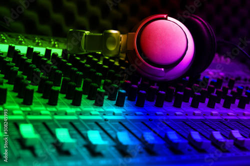 Close-up of boutique recording studio control desk, dj headphones for professional disc,  equipment for sound recording studio, mixer and DJ headphones