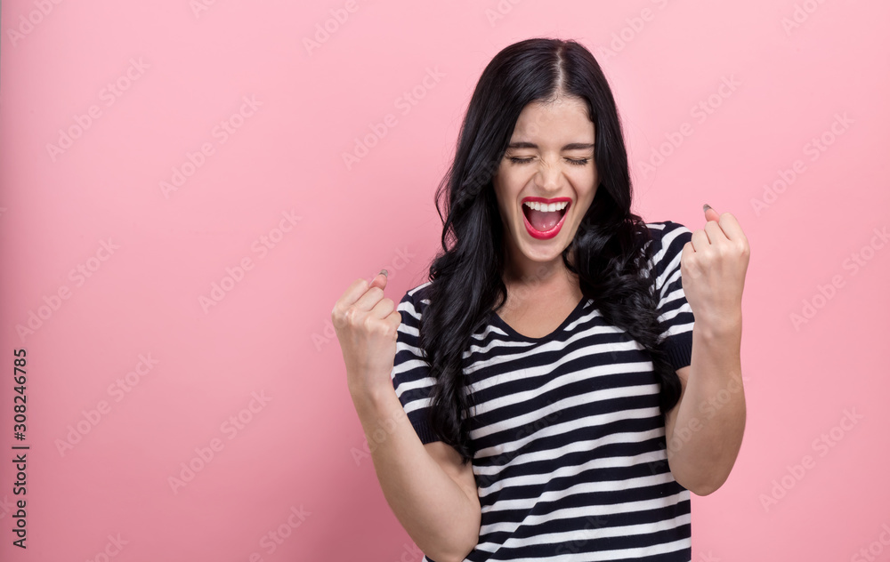 Happy young woman making a yay gesture on a pink background Happy young woman making a yay gesture on a pink background