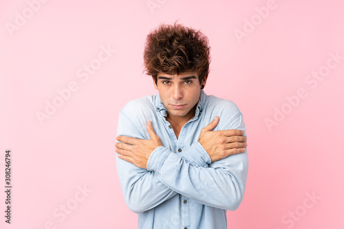 Young caucasian man with jean shirt over isolated pink background freezing © luismolinero