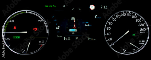 Car dashboard in hybrid car. Close up shot of display indicating battery charge level, speedometer, power monitor, odometer, fuel gauge. Car counter showing energy monitor of engine and battery use.