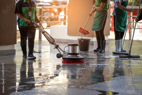 worker using scrubber machine for cleaning and polishing floor