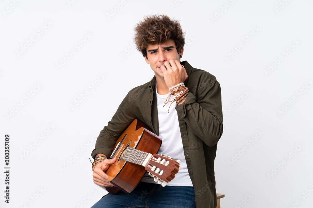 Young caucasian man with guitar over isolated white background nervous and scared Young caucasian man with guitar over isolated white background nervous and scared