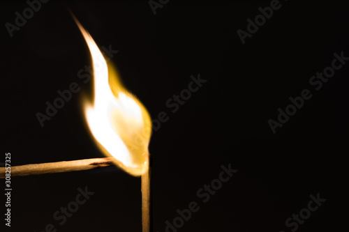 A flammable match with another match in the dark