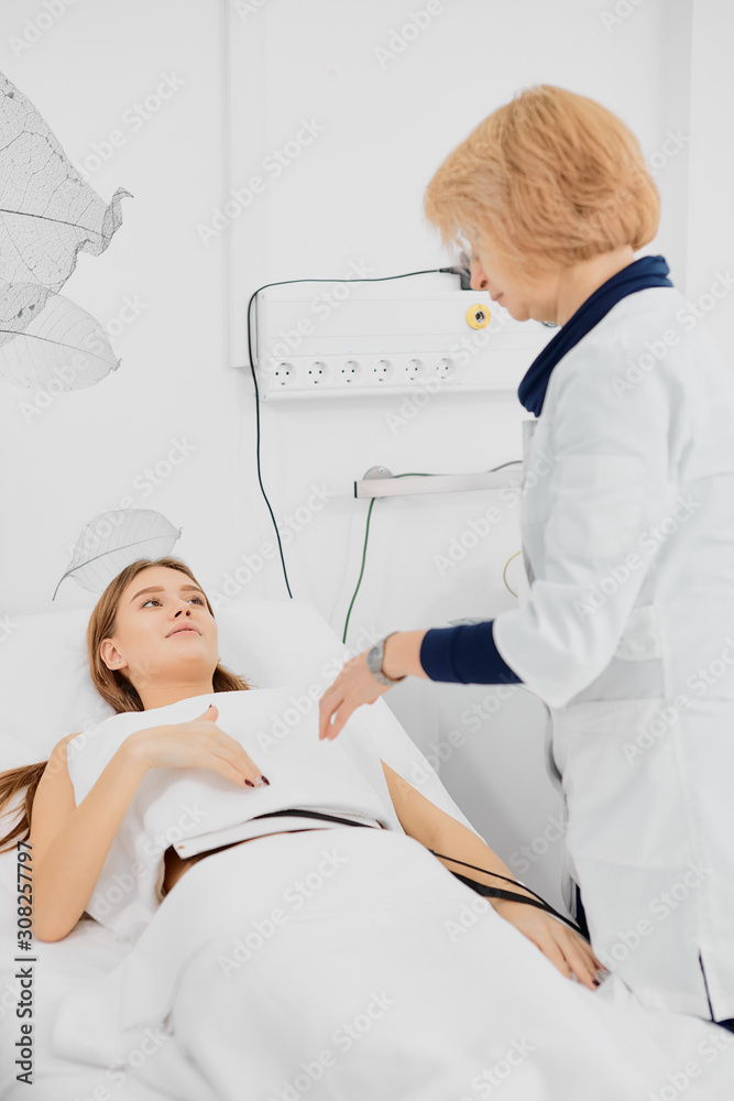 worried female patient lying on bed and careful doctor taking care of her in hospital worried female patient lying on bed and careful doctor taking care of her in hospital
