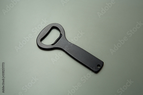 black bottle opener on green and drey background