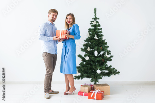 Holidays and celebration concept - Man giving a Christmas present to his girlfriend