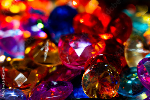 Multi-colored glass pebbles glow in the dark with bright saturated colors. Close-up. Multi-colored faceted glass stones