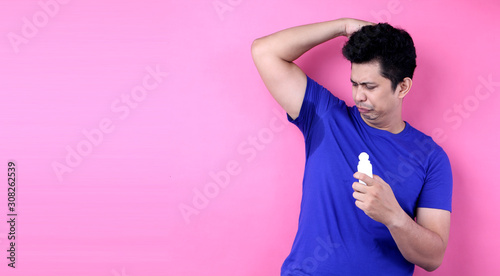  Asia Man sweating excessively smelling bad isolated on pink  background in studio With copy space.