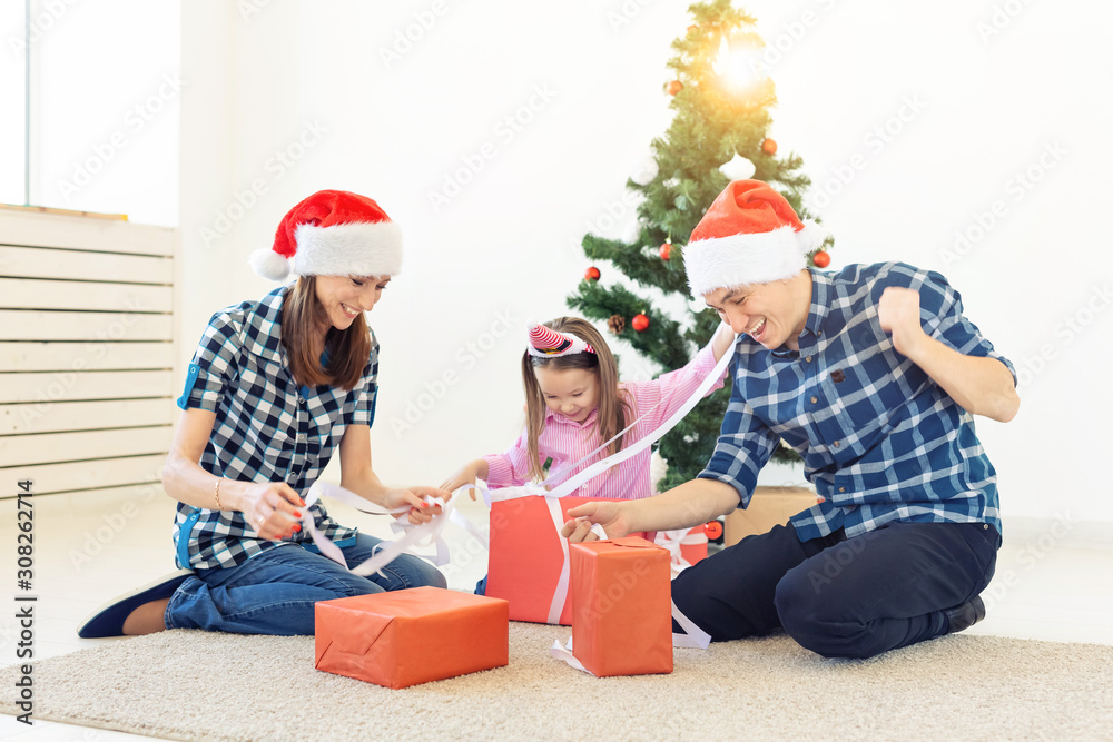 Holidays and presents concept - Portrait of a happy family opening gifts at Christmas time Holidays and presents concept - Portrait of a happy family opening gifts at Christmas time