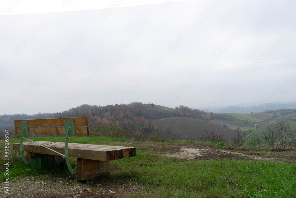 Lonely bench facing a natural landscape with hills Lonely bench facing a natural landscape with hills