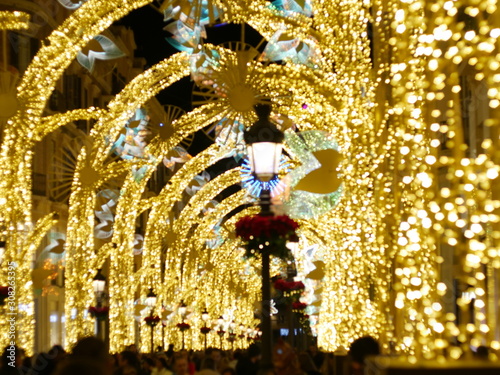 Colorful christmas lights illuminating the streets of Malaga, Andalusia, Spain, in colors of gold, blue and red during holiday season